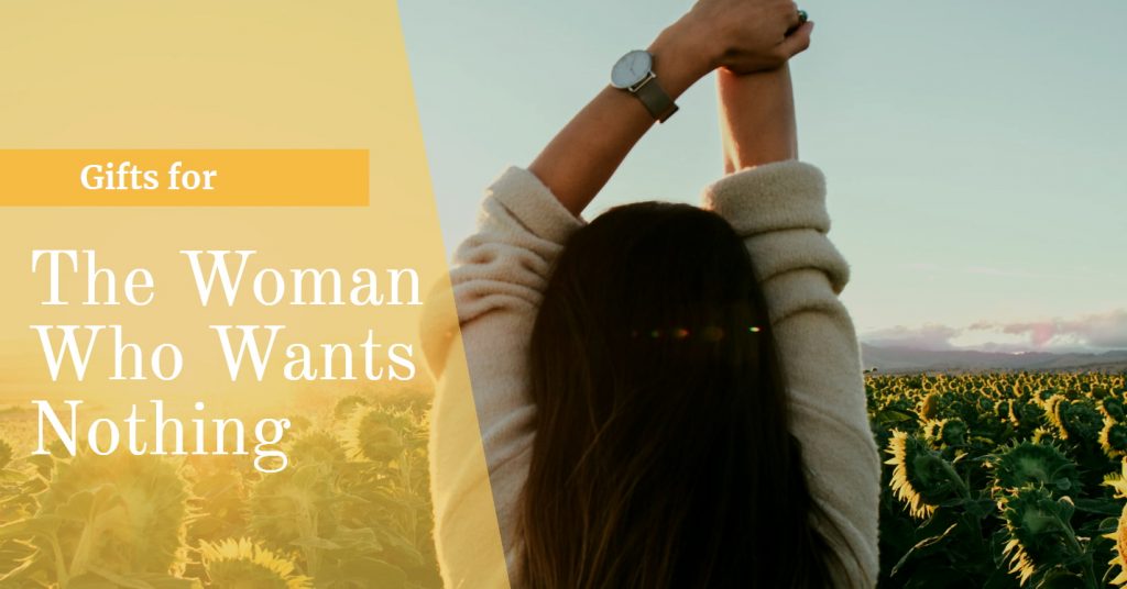 Image of a woman and a sunflower field with her arms raised above her head inferring her happiness because someone bought her the perfect gift for the woman who wants nothing