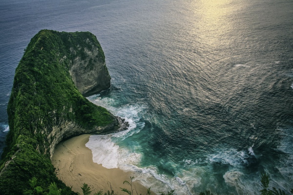 Image of the ocean and a large rock at exotic destination location Bali Indonesia