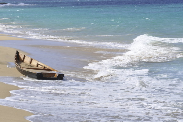 Photo of a small wooden boat washed up on the shore of Puerto Rico